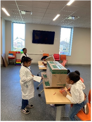 Kids in lab coats at the Martens Center learning about High Performance Computing as part of the I-Sci Explorer programming